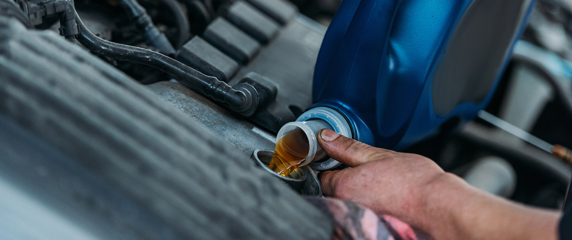 Cropped shot of automechanic changing motor oil in a repair shop.